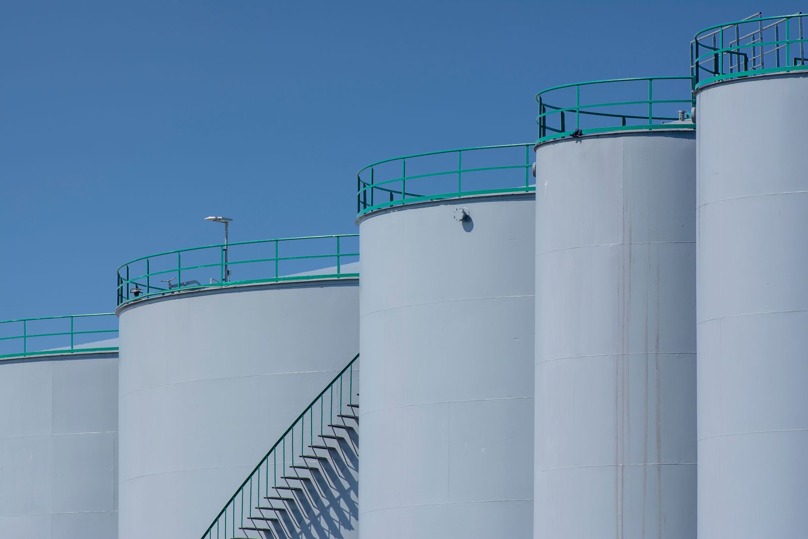 Industrial storage tanks beneath a clear blue sky